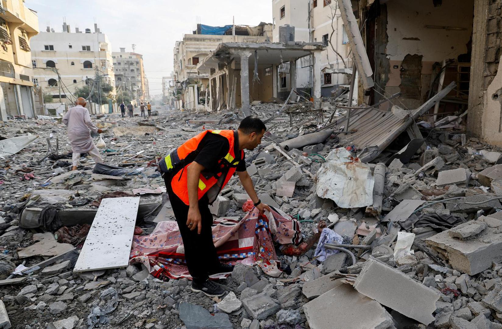 SENSITIVE MATERIAL. THIS IMAGE MAY OFFEND OR DISTURB    A rescuer holds a sheet covering the body of a Palestinian in the aftermath of Israeli strikes, in Gaza City, October 11, 2023. REUTERS/Mohammed Salem REFILE - CORRECTING "NORTHERN GAZA STRIP" TO "GAZA CITY\ Photo: MOHAMMED SALEM/REUTERS