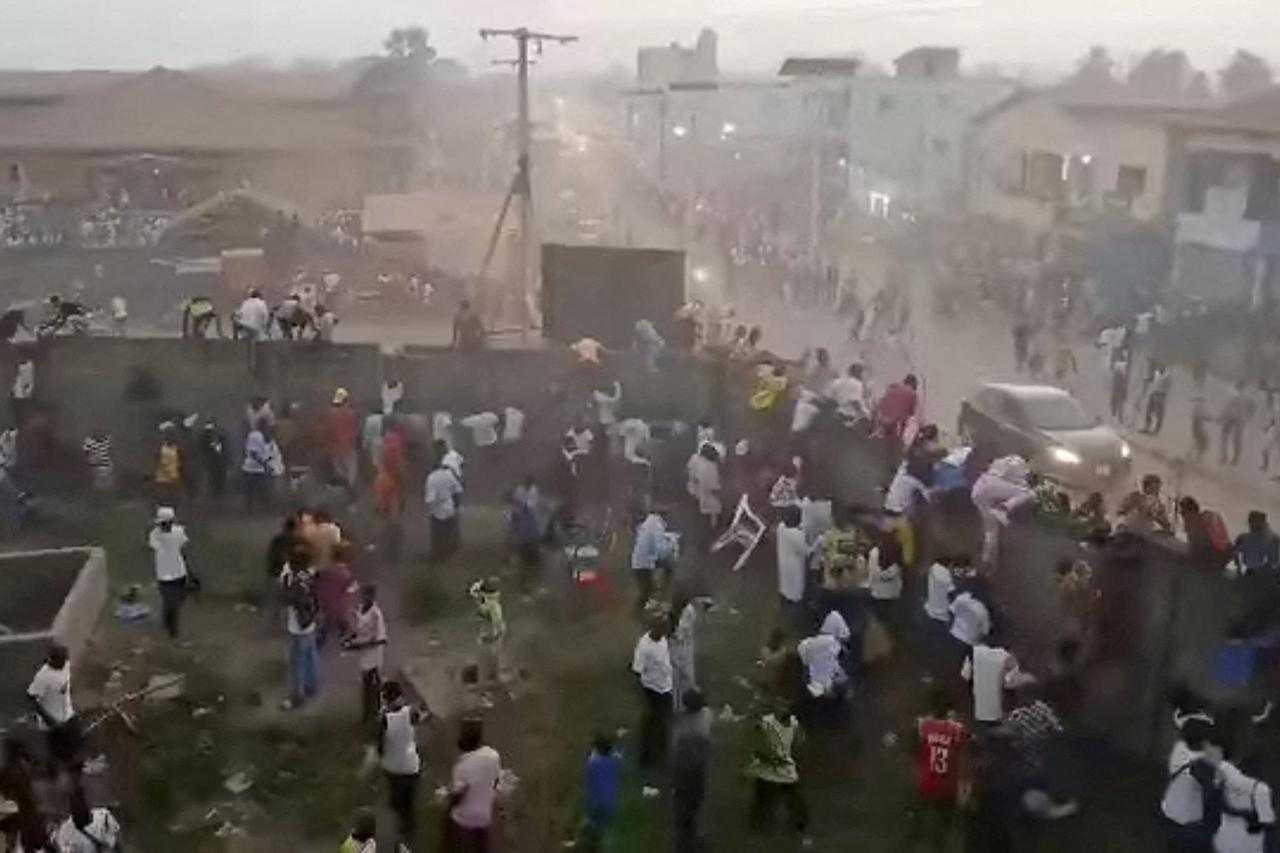 People scramble in Nzerekore where local officials said a stampede occurred following clashes at a soccer match