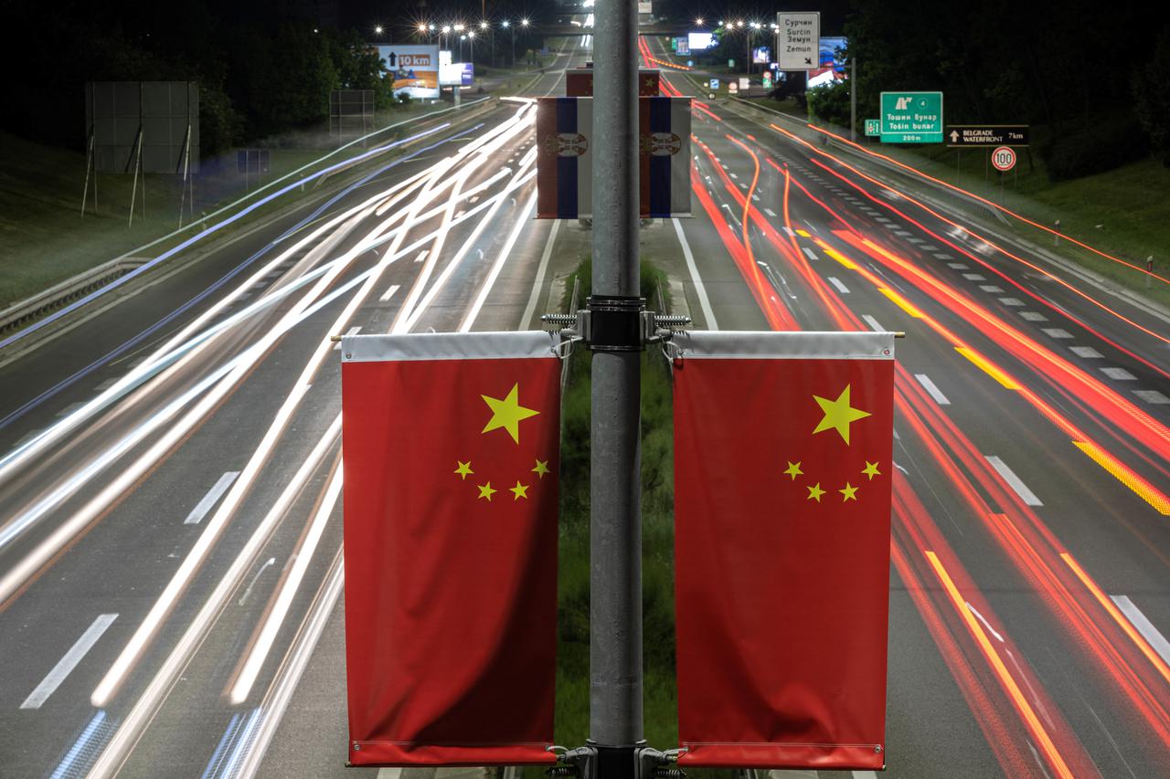 Cars pass Chinese flags on a highway ahead of Chinese President Xi Jinping's visit in Belgrade