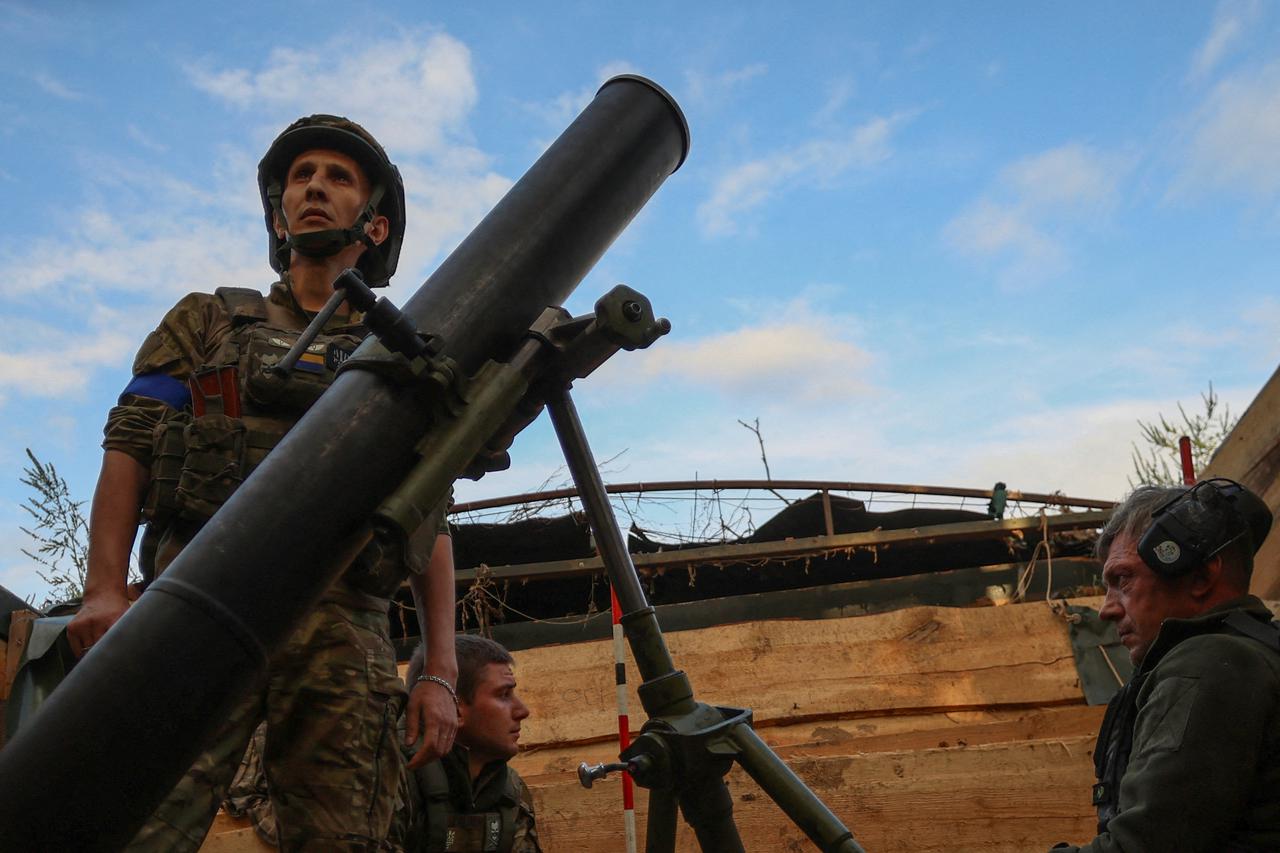 FILE PHOTO: Ukrainian service members wait before fire a mortar toward Russian troops at their position near a frontline in Zaporizhzhia region