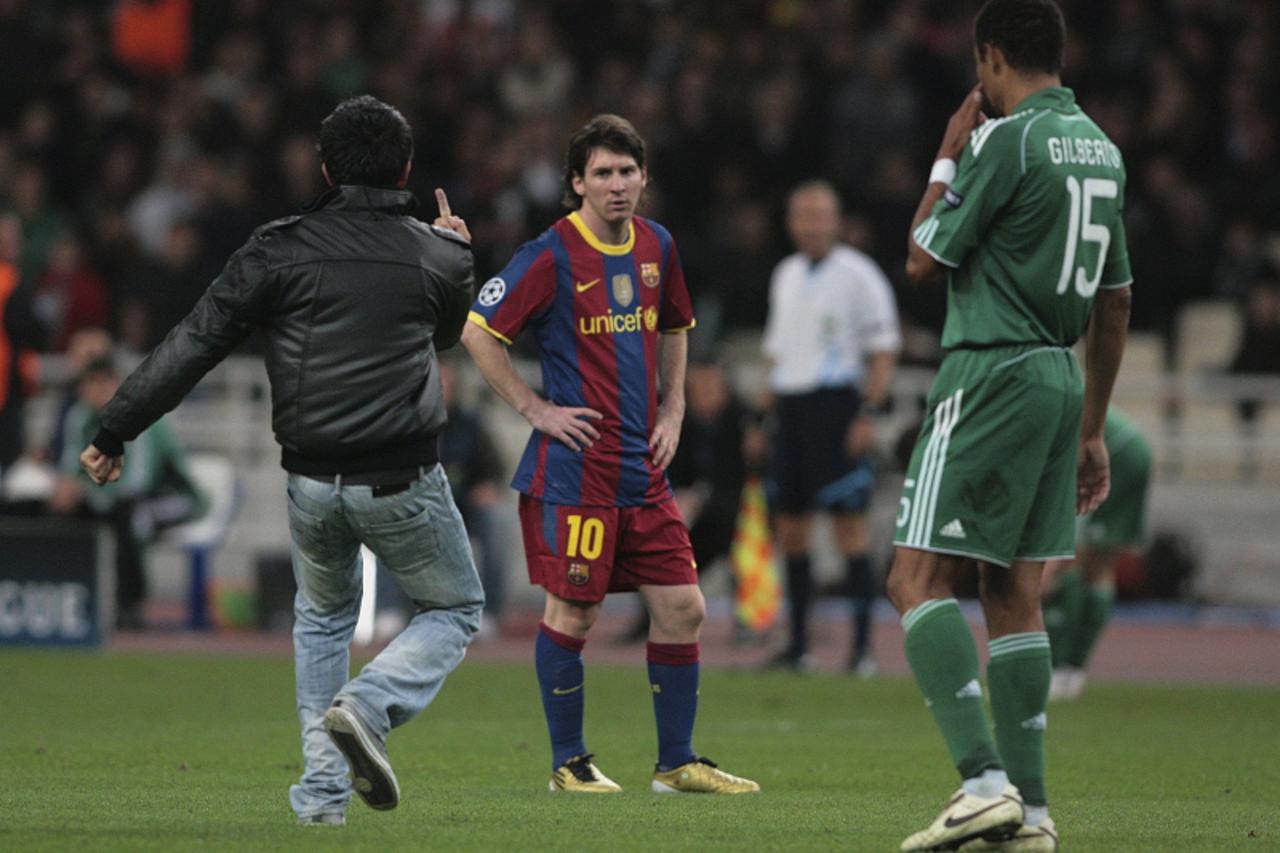 \'An unidentified Panathinaikos FC supporter makes an obscene gesture to Lionel Messi (C) of FC Barcelona in the second half of the Champions League Group D soccer match at Olympic stadium in Athens N