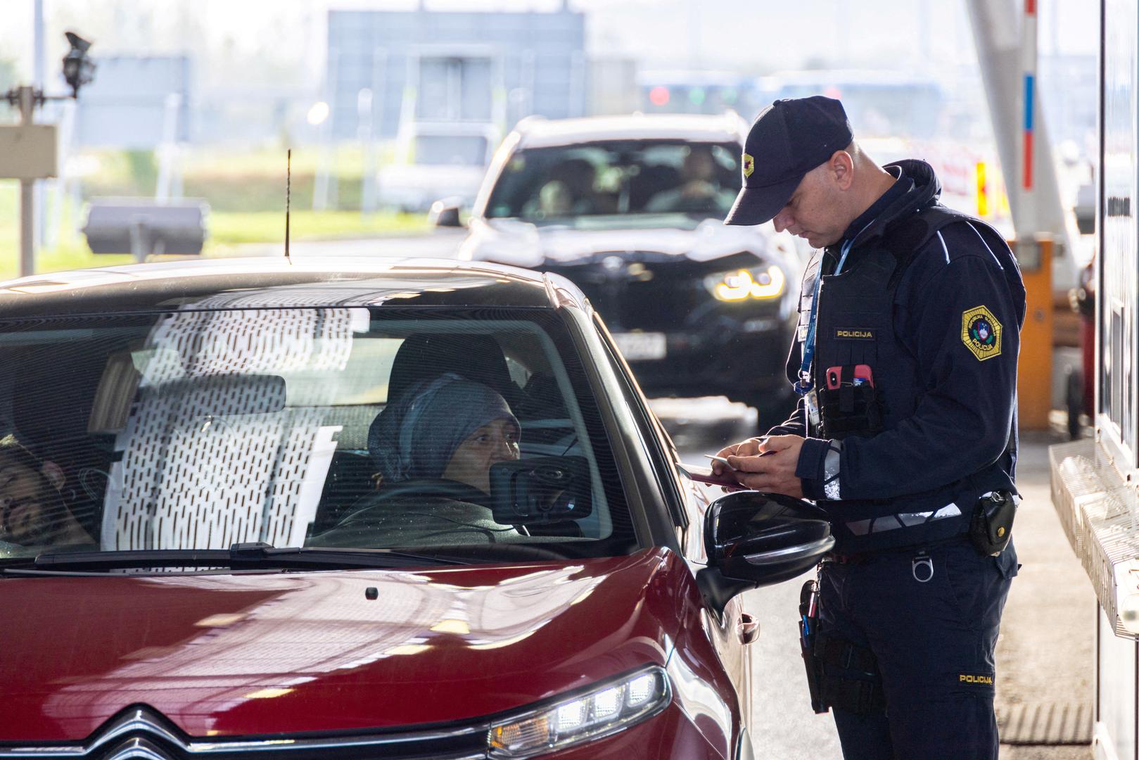 A Police officer inspects documents at the border crossing in Obrezje, Slovenia, October 21, 2023. REUTERS/Antonio Bronic Photo: Antonio Bronic/REUTERS