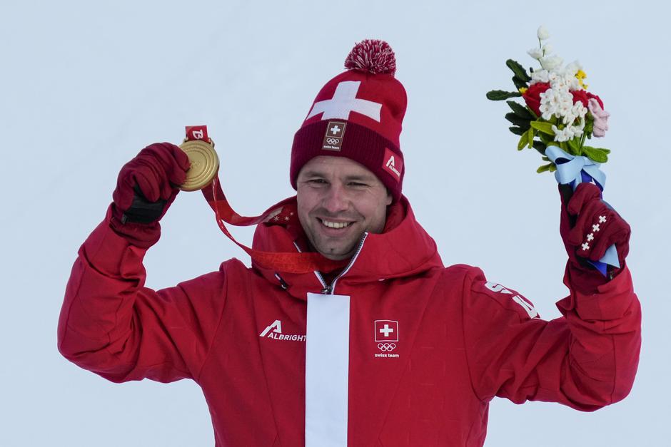 Winners hold up medals at the Men's Downhill race at the Beijing 2022 Winter Olympics