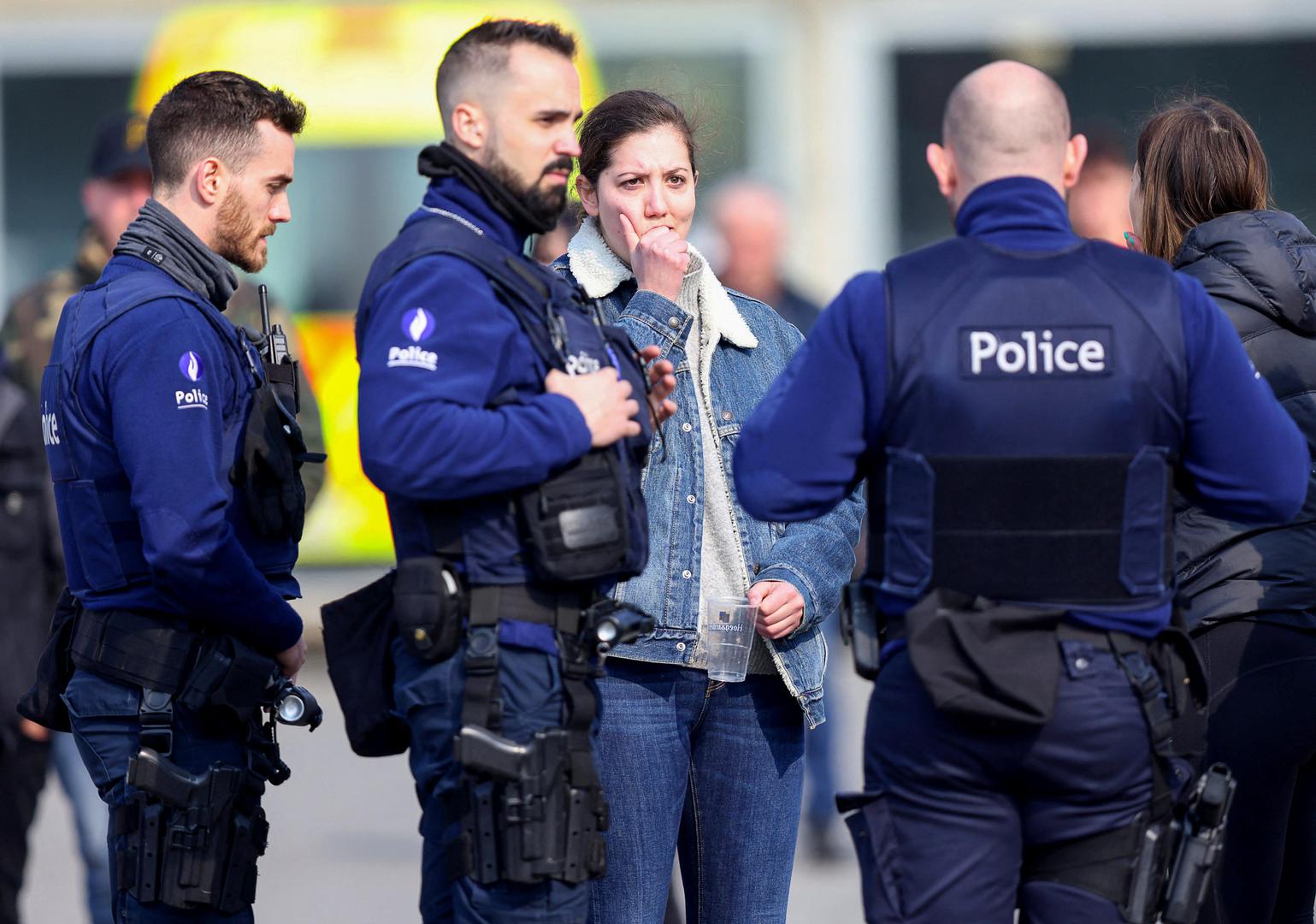 A woman reacts as police officers keep guard after a vehicle drove into a group of Belgian carnival performers who were preparing for a parade in the village of Strepy-Bracquegnies, Belgium March 20, 2022. REUTERS/Johanna Geron Photo: JOHANNA GERON/REUTERS