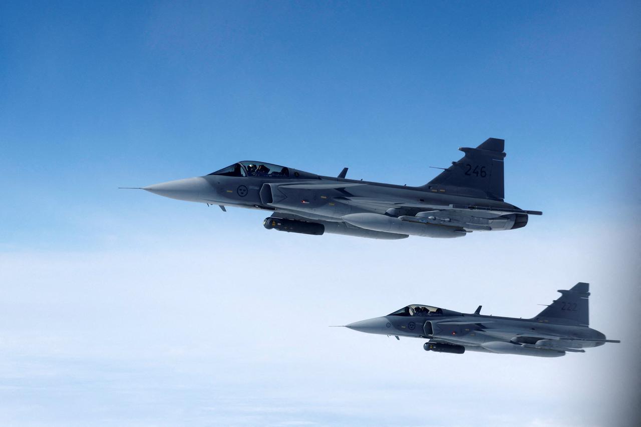 FILE PHOTO: Swedish Air Force Saab JAS 39 Gripen fighter jets fly alongside an aircraft simulating aerial interceptions during a media day