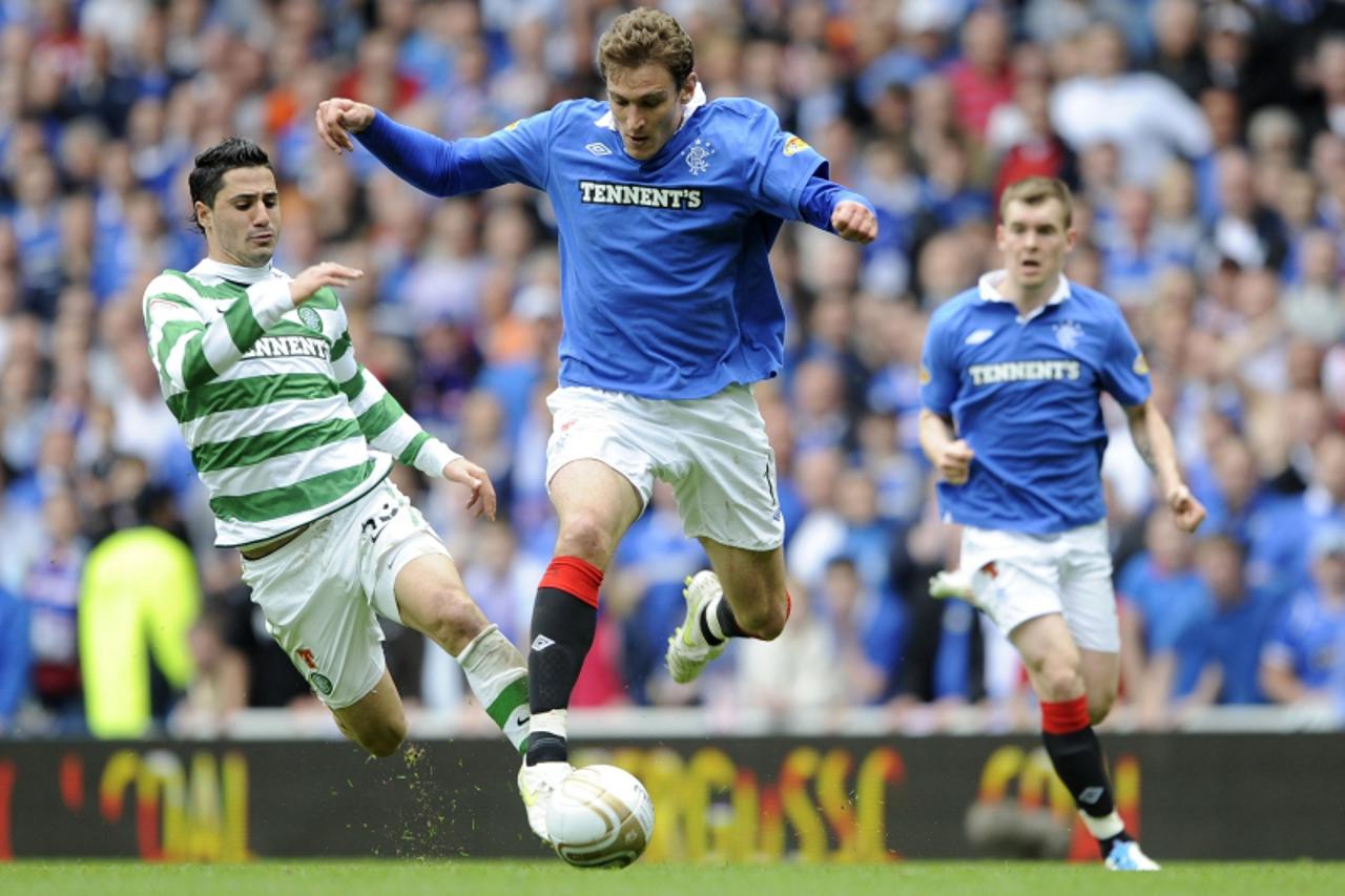 'Rangers\' Nikica Jelavic (C) is challenged by Celtic\'s Beram Kayal during their Scottish Premier League soccer match at Ibrox Stadium, Glasgow, Scotland, April 24, 2011. REUTERS/Russell Cheyne (BRIT