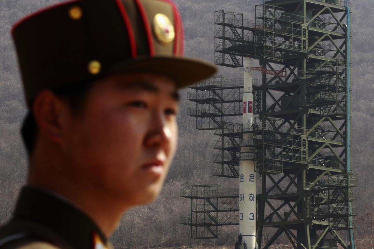 \'A soldier stands guard in front of the Unha-3 (Milky Way 3) rocket sitting on a launch pad at the West Sea Satellite Launch Site, during a guided media tour by North Korean authorities in the northw