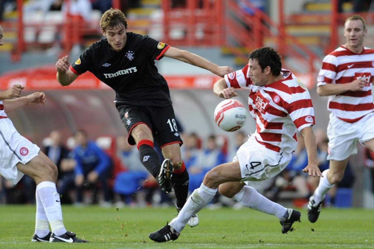 \'Hamilton\'s Jim Goodwin (L) and Martin Canning challenge Rangers\' Nikica Jelavic during their Scottish Premier League soccer match at New Douglas Park, Hamilton, Scotland, September 11, 2010. REUTE