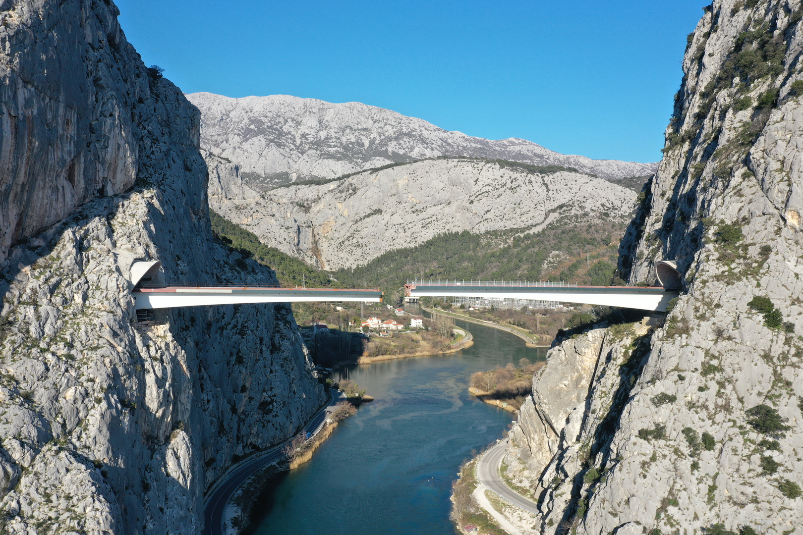 09.02.2023., Omis - Spajanje mosta iznad rijeke Cetine kod Omisa na 70 metara nadmorske visine koji je dio omiske zaobilaznice. Omiska obilaznica jedan od najvecih infrastrukturnih objekata u Splitsko-dalmatinskoj zupaniji, a zaobilaznicu ukljucuju dva tunela i most preko Cetine, tunel Komorjak dug vise od 600 metara, a Omis vise od 500 metara, dok ce most biti u duzini od 216 metara. Investitor je tvrtka Hrvatske ceste, koja je za prvu fazu brze ceste Split - Omis izdvojila 174,5 milijuna kuna, a s radovima se pocelo u rujnu 2019.  Photo: Matko Begovic/PIXSELL