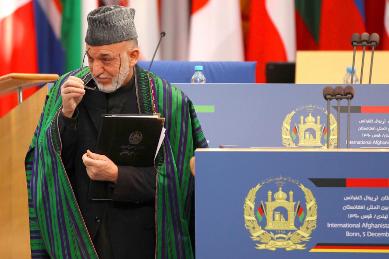 'Afghan President Hamid Karzai leaves the podium after addressing the Afghanistan Conference on December 5, 2011, in Bonn, western Germany. The one-day gathering brings around 100 national delegations