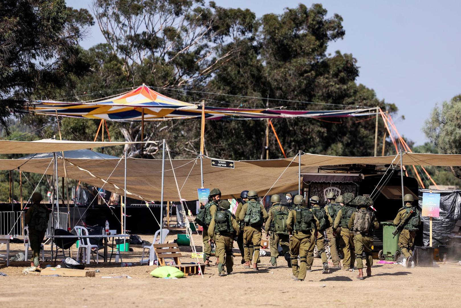 Israeli soldiers walk through the site of an attack on the Nova Festival by Hamas gunmen from Gaza, near Israel's border with the Gaza Strip, in southern Israel, October 12, 2023. REUTERS/Ronen Zvulun Photo: RONEN ZVULUN/REUTERS