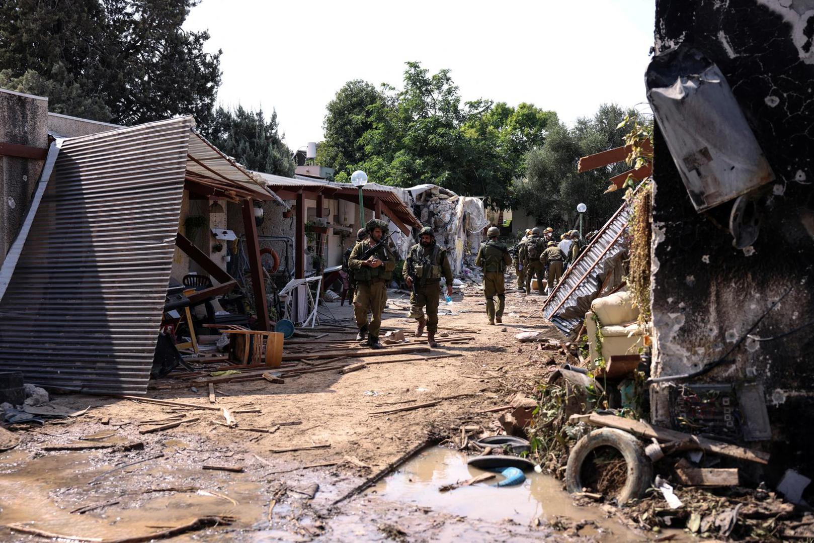 Israeli soldiers walk through the remains of a residential area of Kibbutz Kfar Aza, in southern Israel, October 10, 2023. REUTERS/Ronen Zvulun Photo: RONEN ZVULUN/REUTERS