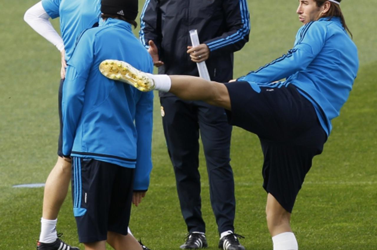 'Real Madrid\'s Sergio Ramos (R) playfully kicks teammate Angel Di Maria during their team\'s training session at Valdebebas training ground in Madrid November 21, 2011. Real Madrid will play their Ch