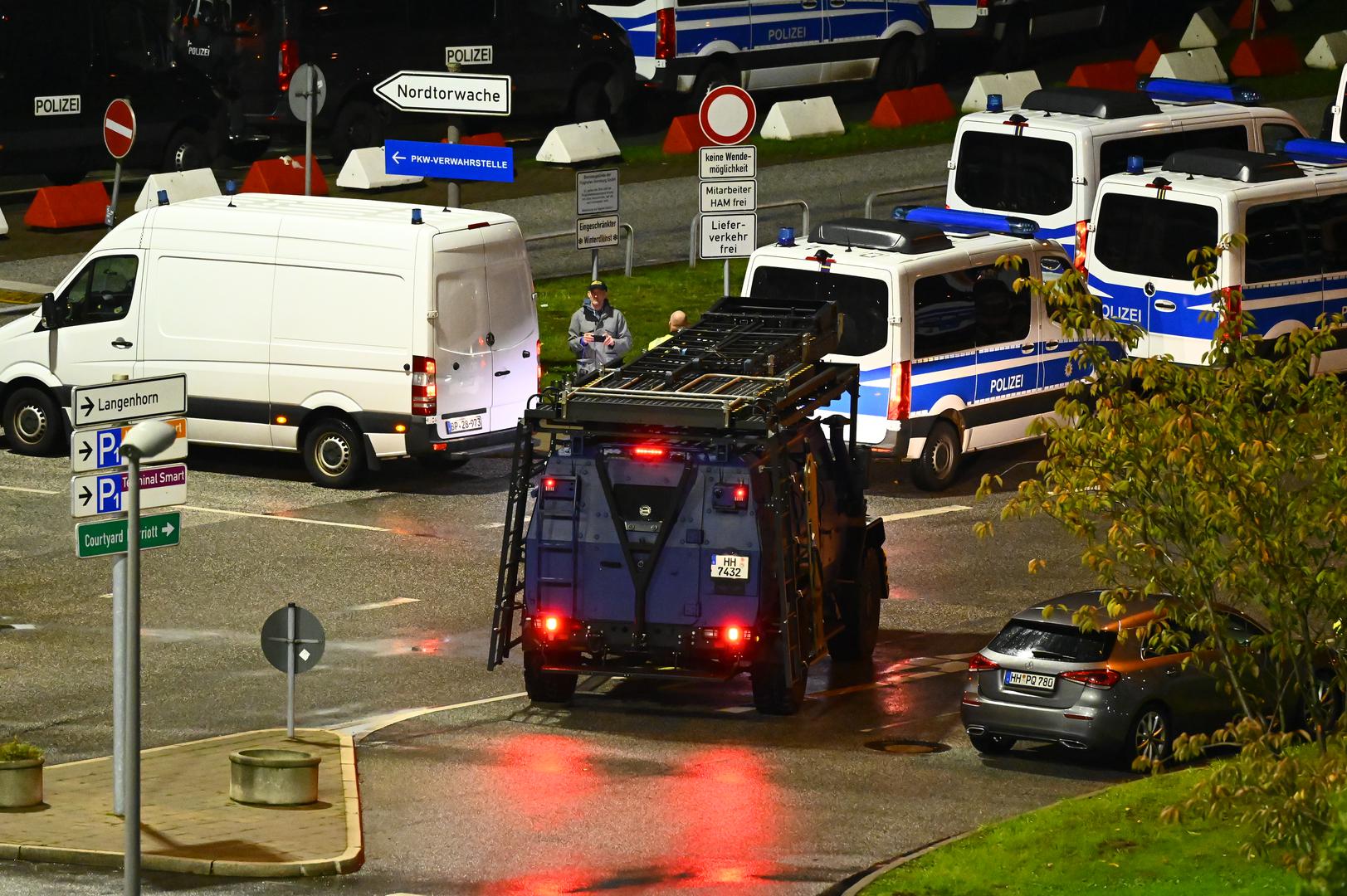 04 November 2023, Hamburg: Police cars and a special vehicle are parked at the airport. Hamburg Airport has been closed after a vehicle entered the premises. A gunman had broken through a gate with his vehicle and had already fired twice into the air, said a spokesman for the federal police on Saturday evening. Photo: Jonas Walzberg/dpa Photo: Jonas Walzberg/DPA