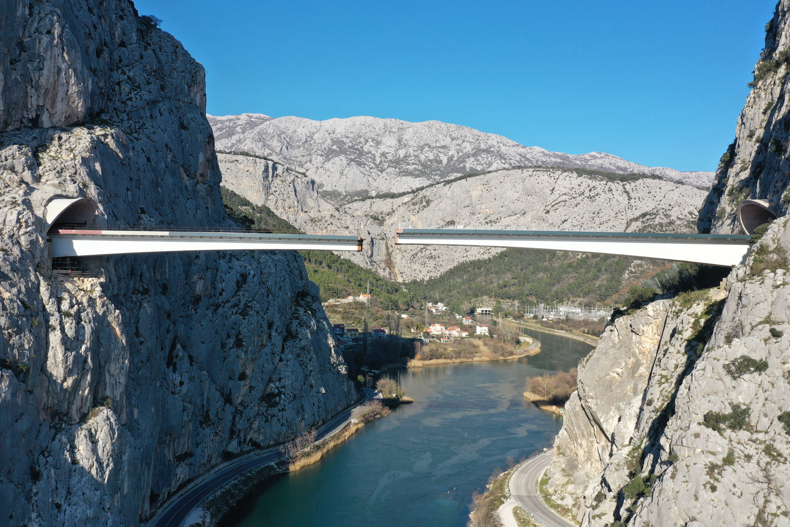 09.02.2023., Omis - Spajanje mosta iznad rijeke Cetine kod Omisa na 70 metara nadmorske visine koji je dio omiske zaobilaznice. Omiska obilaznica jedan od najvecih infrastrukturnih objekata u Splitsko-dalmatinskoj zupaniji, a zaobilaznicu ukljucuju dva tunela i most preko Cetine, tunel Komorjak dug vise od 600 metara, a Omis vise od 500 metara, dok ce most biti u duzini od 216 metara. Investitor je tvrtka Hrvatske ceste, koja je za prvu fazu brze ceste Split - Omis izdvojila 174,5 milijuna kuna, a s radovima se pocelo u rujnu 2019.  Photo: Matko Begovic/PIXSELL