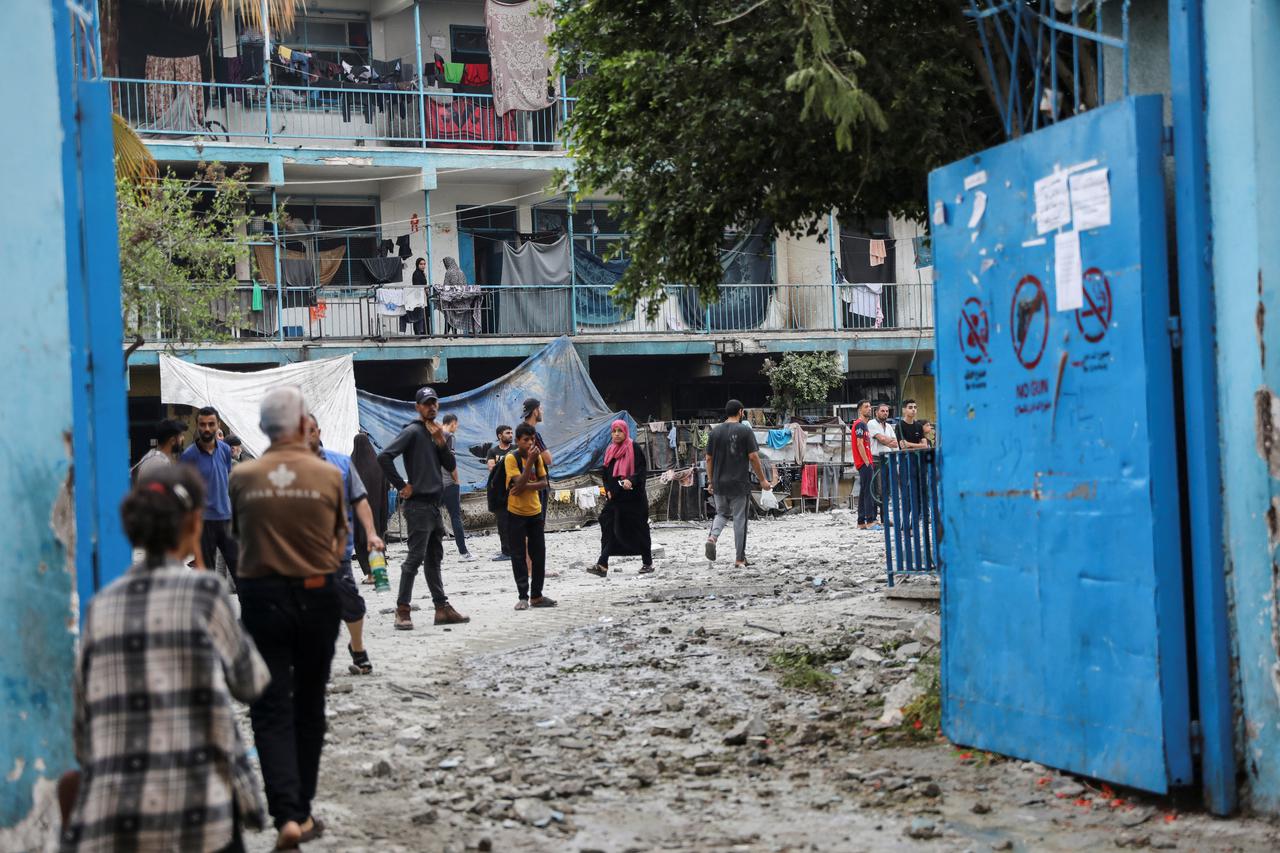 Palestinians inspect the site of an Israeli strike on a UNRWA school sheltering displaced people, in Nuseirat refugee camp