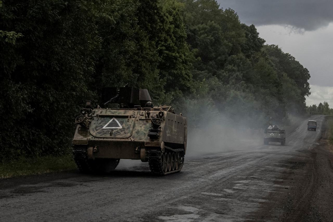 Ukrainian soldiers ride armoured personnel carriers near the Russian border in Sumy region