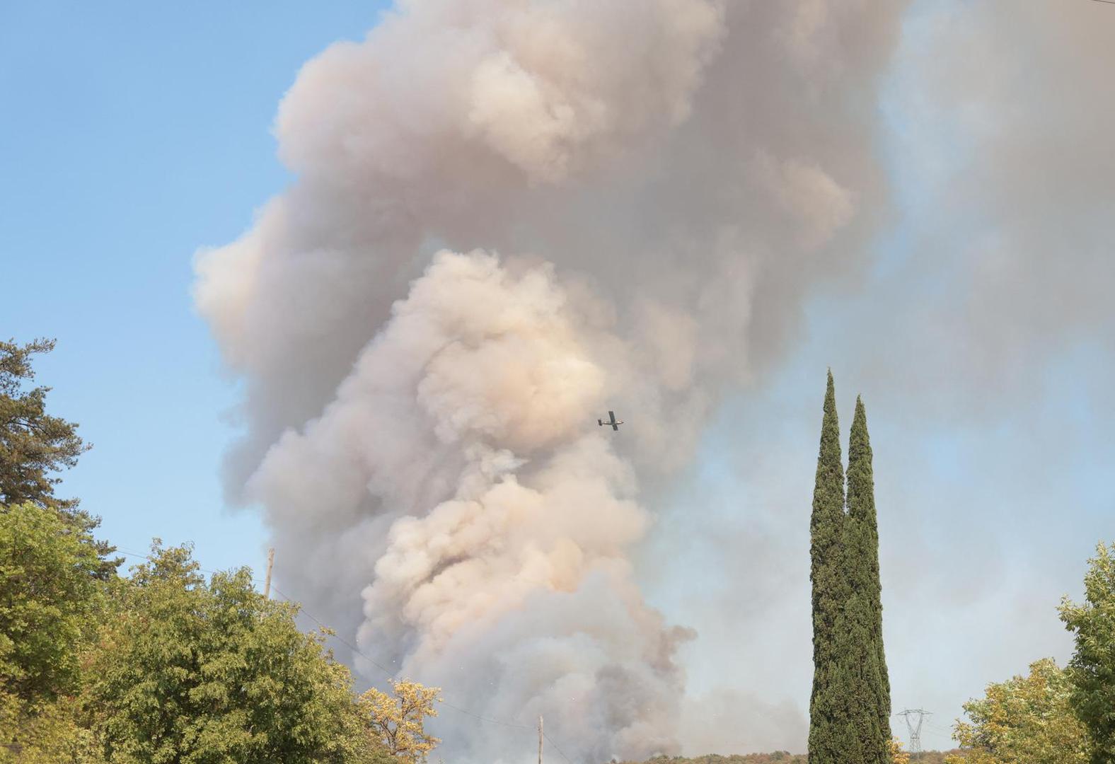 A plane flies as smoke that billows from a wildfire over the border with Slovenia is seen from Rupa, Italy, July 20, 2022. REUTERS/Borut Zivulovic Photo: BORUT ZIVULOVIC/REUTERS