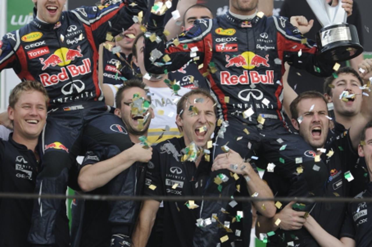 'German F-1 driver Sebastian Vettel and Australian Mark Webber celebrate with their team after the  2011 Brazil F-1 GP at Interlagos on November 27, 2011. Australian Mark Webber won the race and quali