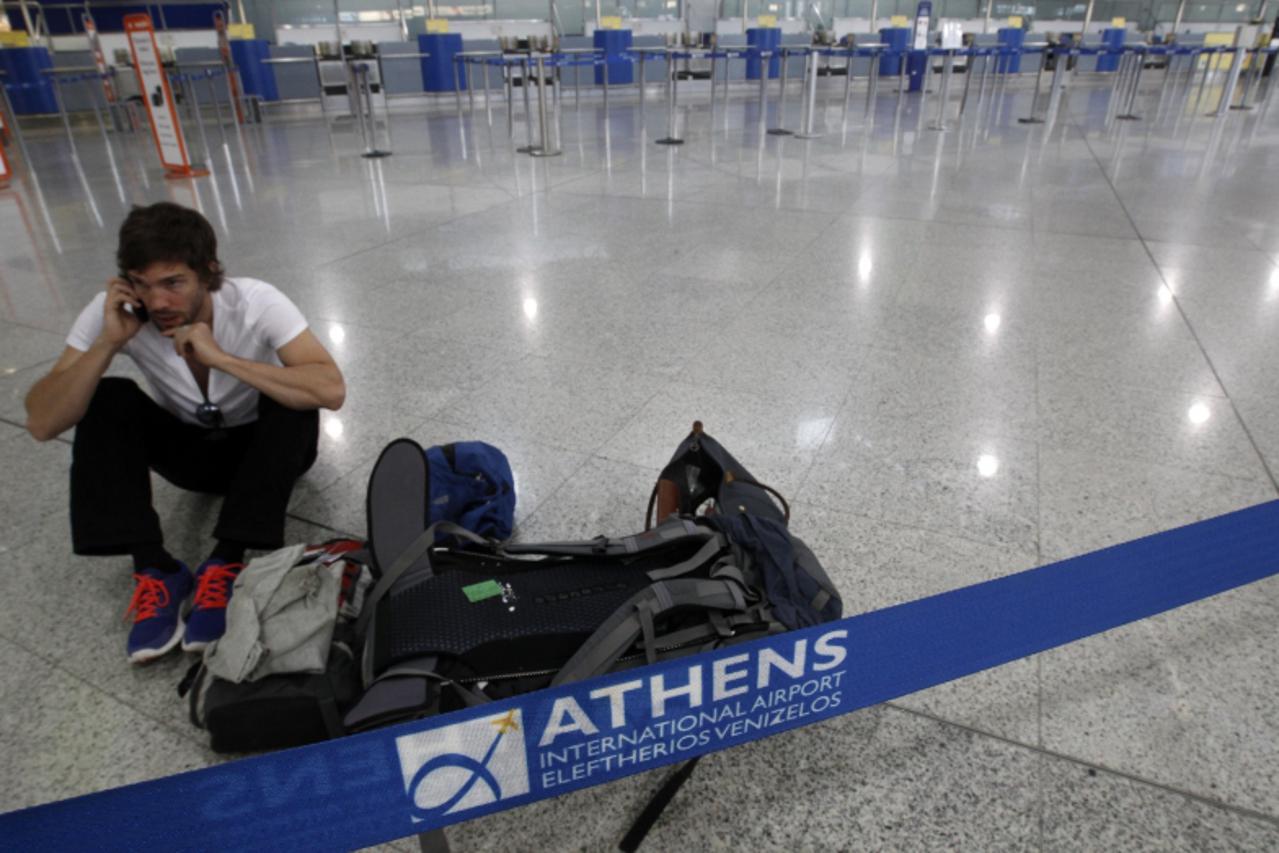 'A passenger sits inside an empty hall at the Athens Eleftherios Venizelos airport during a 24-hour labour strike in Athens October 5, 2011. Airliners were grounded, trains halted and tax offices shut