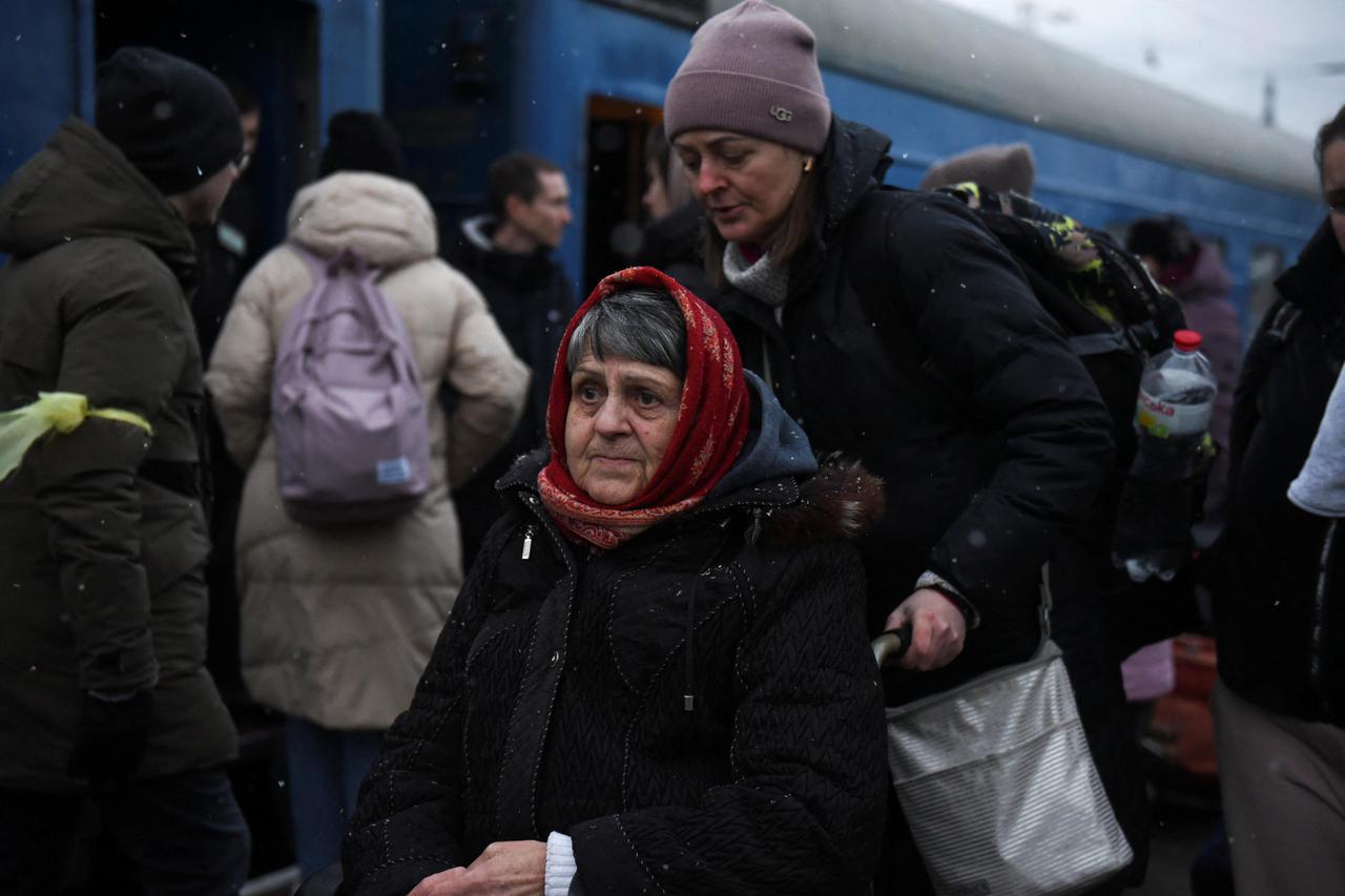 A woman on a wheelchair waits to board a train during snowfall, as civilians flee Russia's invasion of Ukraine, in Odessa