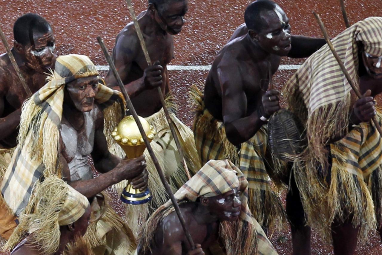 'A dancer in a traditional outfit holds the trophy to be presented to the Zambian team after they won the 2012 African Cup of Nations tournament final match against Ivory Coast at the Stade De L\'Amit