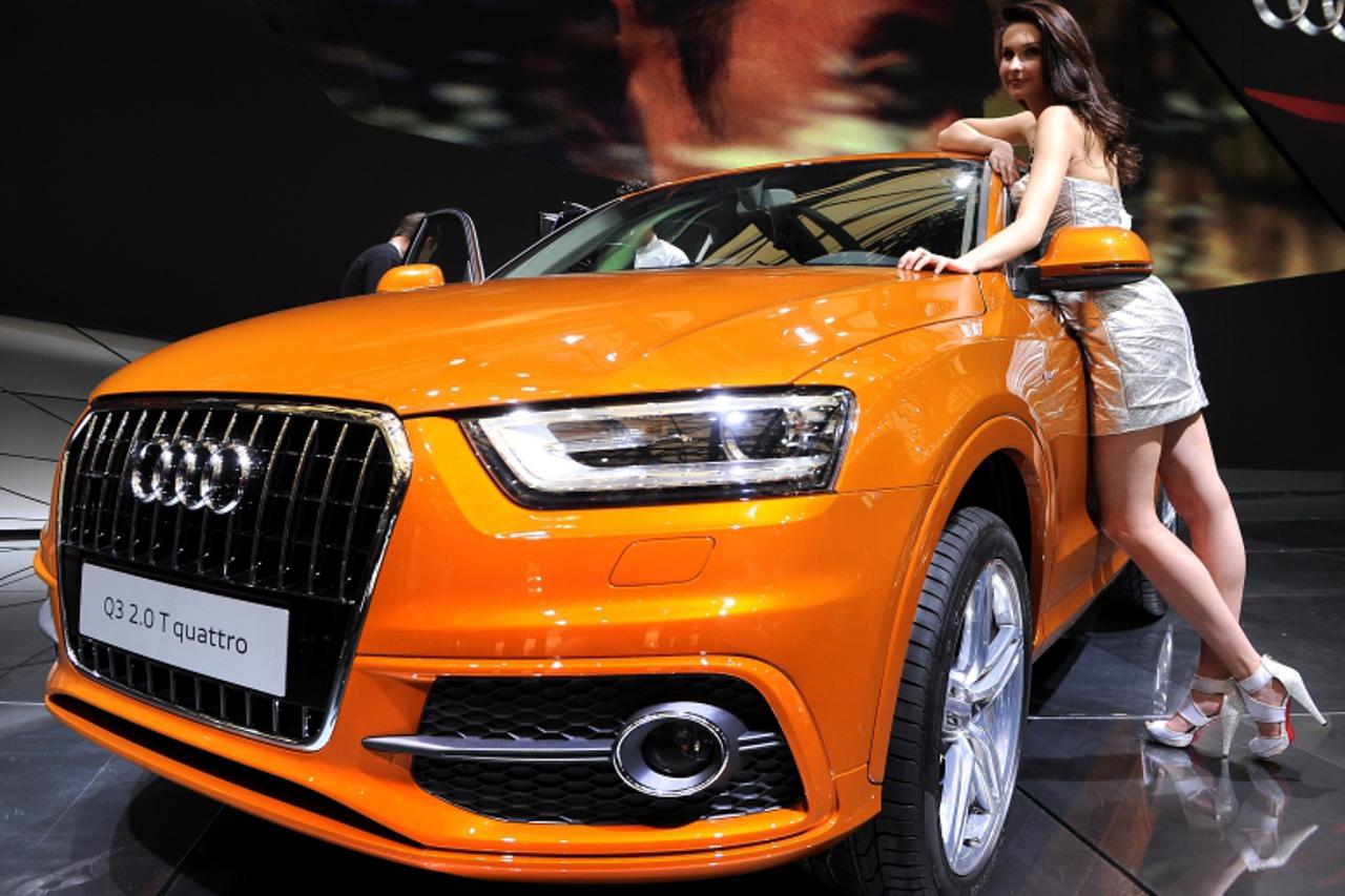 'A model poses next to the New Audi Q3 Quattro displayed at the Shanghai Auto Show in Shanghai on April 20, 2011. About 2,000 car and parts makers from 20 countries are participating in the Shanghai a