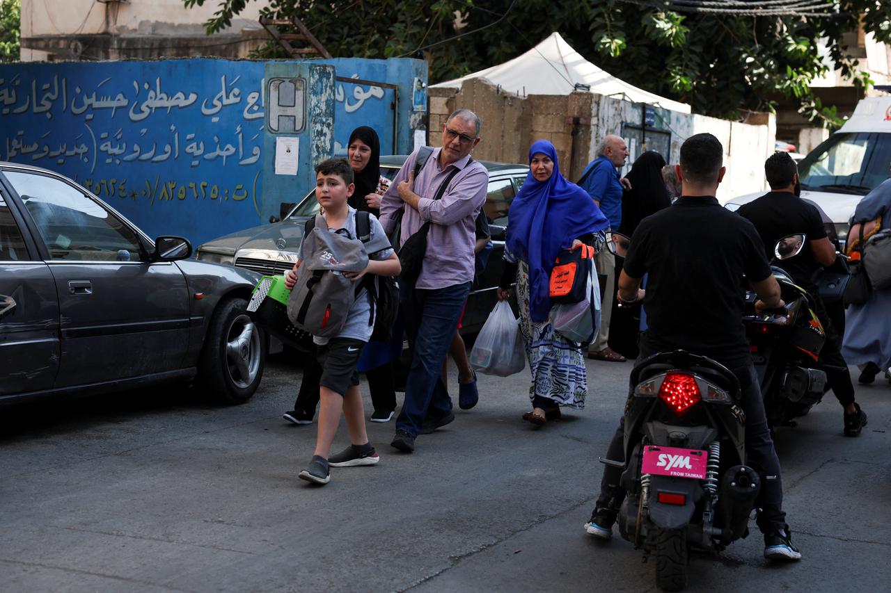 People gather near the site of an Israeli strike in Beirut's southern suburbs