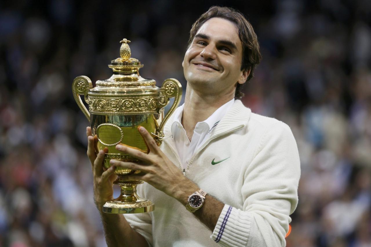 'REFILE - CORRECTING BYLINE  Roger Federer of Switzerland holds the winners trophy after defeating Andy Murray of Britain in their men\'s singles final tennis match at the Wimbledon Tennis Championshi