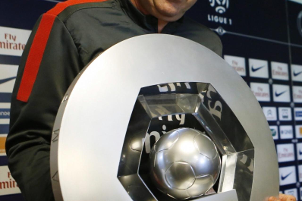 'Paris Saint-Germain's coach Carlo Ancelotti holds the French Championship trophy after a news conference at the Camp des Loges training center in Saint-Germain-en-Laye, near Paris, May 17, 2013.  RE