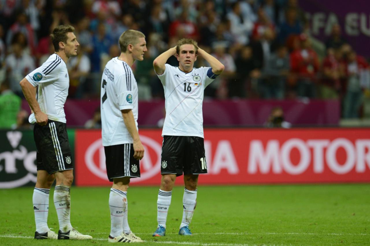 '(FromL) German forward Miroslav Klose, midfielder Bastian Schweinsteiger and defender Philipp Lahm react at the end of the Euro 2012 football championships semi-final match Germany vs Italy on June 2