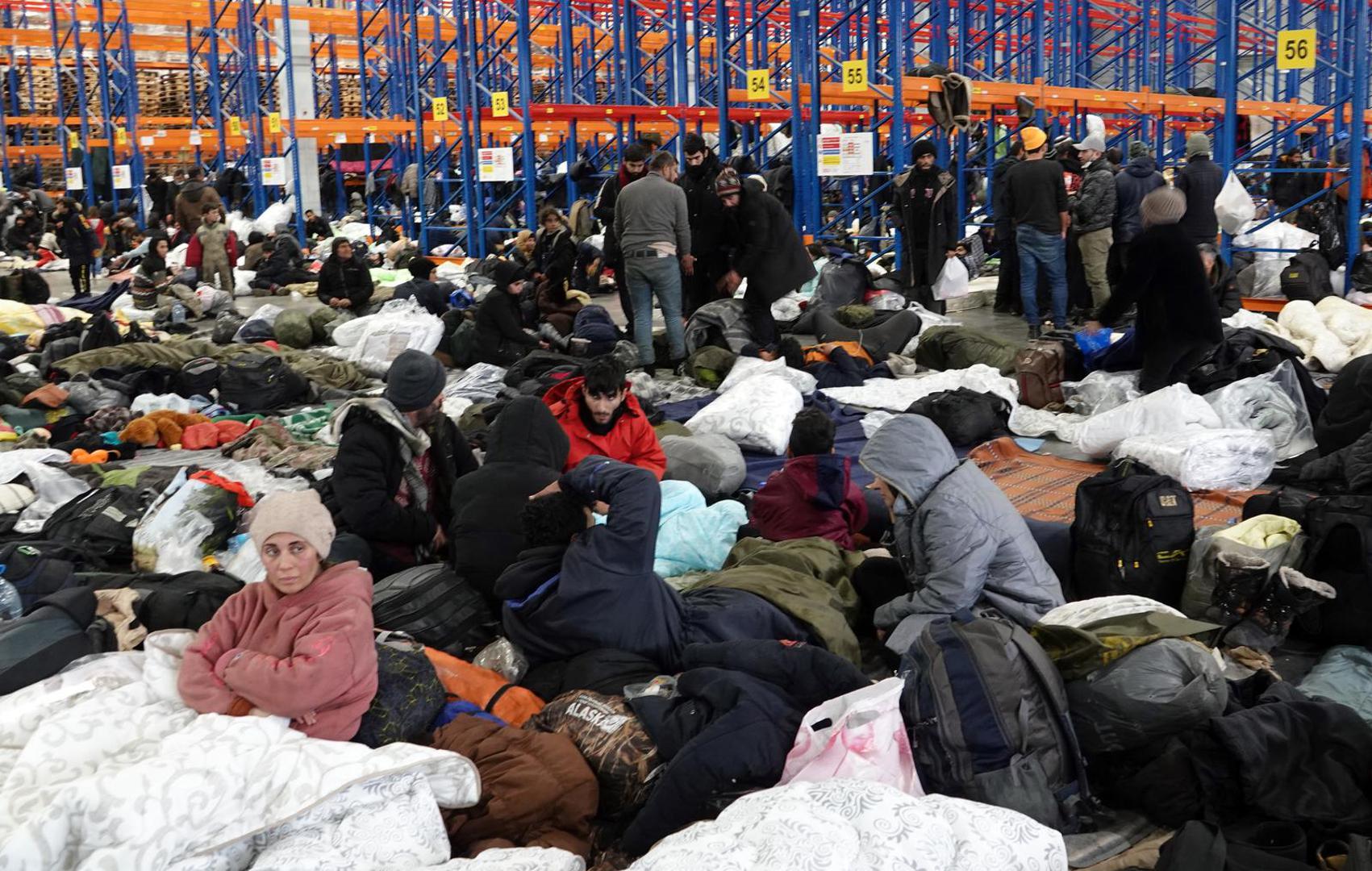 dpatop - 18 November 2021, Belarus, Brusgi: Migrants are in the emergency shelter in the warehouse of a logistics center near the border with Poland. Photo: Ulf Mauder/dpa