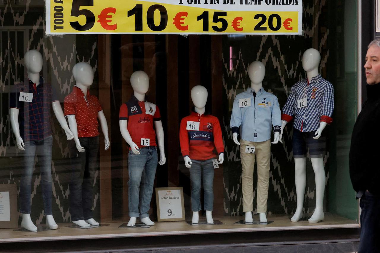 FILE PHOTO: Mannequins are displayed with the price in Euros on a showcase of a clothes store, in Ronda