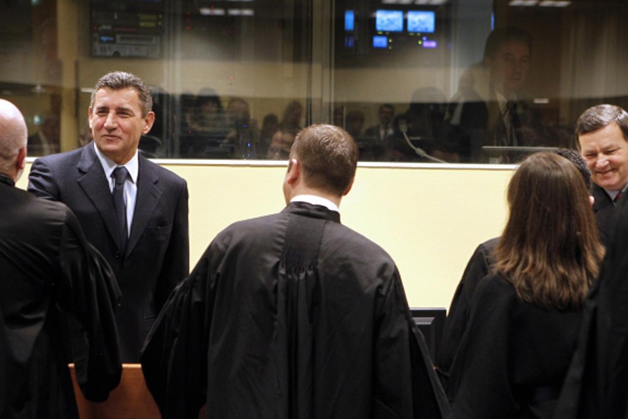 'Former Croatian Army General Ante Gotovina (back, L) and Mladen Markac (back, R) shake hands with their lawyers in the courtroom of the International Criminal Tribunal for the former Yugoslavia (ICTY