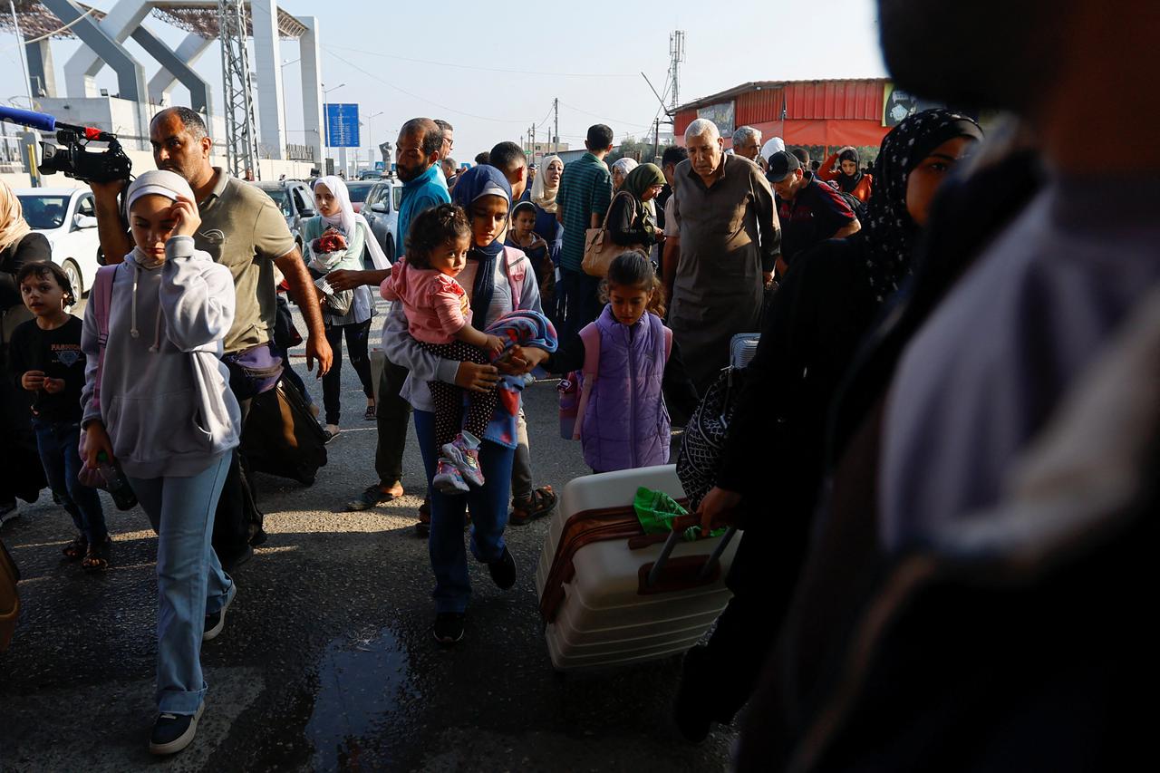 Palestinians with dual citizenship wait for permission to leave Gaza, at the Rafah border crossing with Egypt