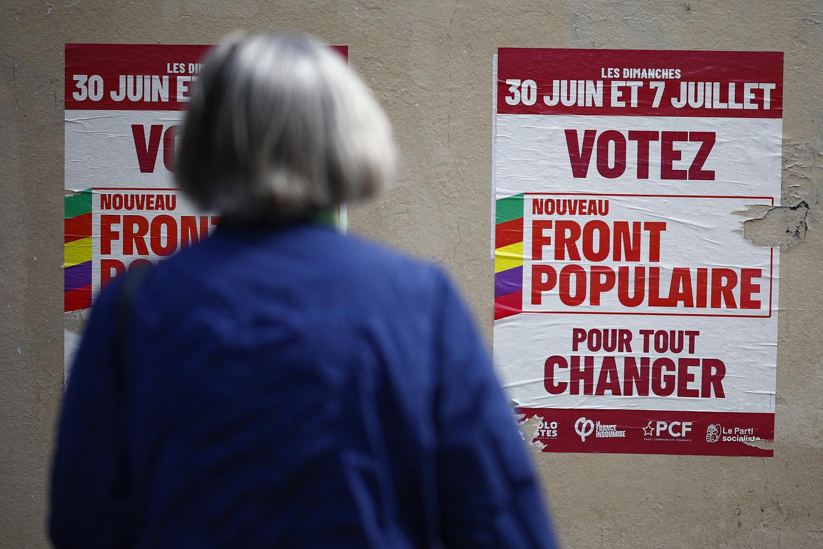 A woman looks at campaign posters of the French left-wing alliance, named the Nouveau Front Populaire (New Popular Front - NFP) on the day of the second round of the early French parliamentary elections, in Paris, France, July 7, 2024. The slogan reads " Vote New Popular Front to change everything".  REUTERS/Sarah Meyssonnier Photo: Sarah Meyssonnier/REUTERS