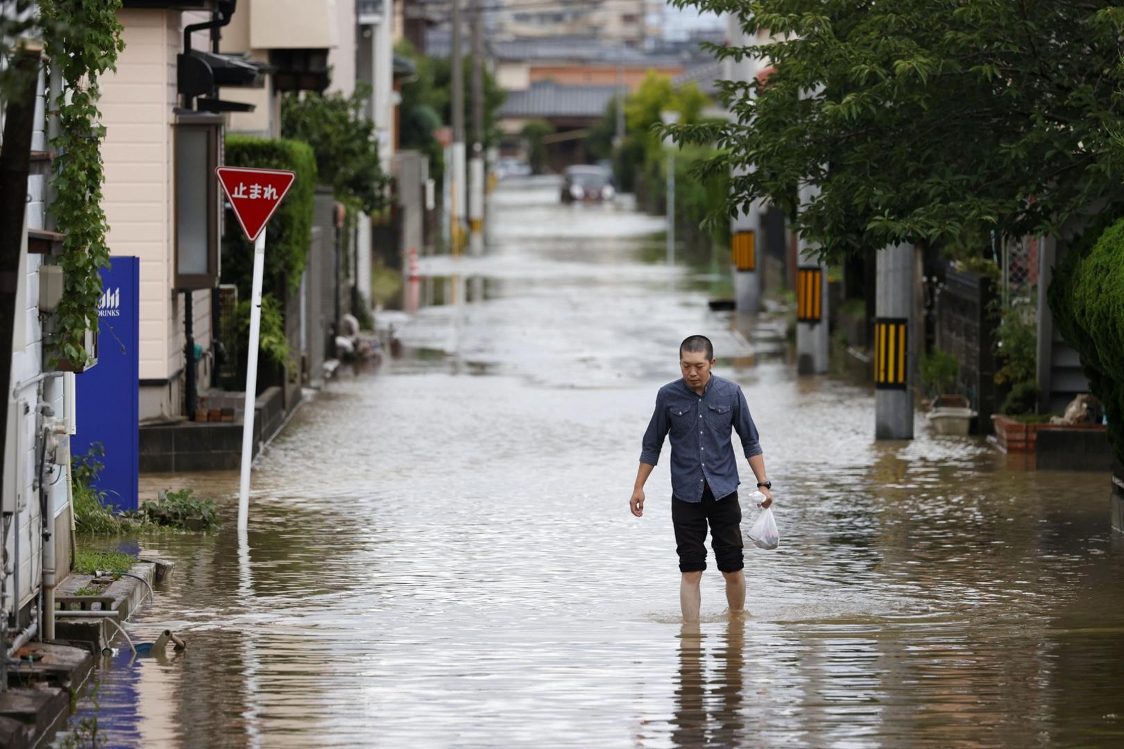 A man walks on a flooded street in Omuta, Fukuoka Prefecture, southwestern Japan, on July 7, 2020, after deadly torrential rain. (Kyodo)
==Kyodo
 Photo via Newscom Newscom/PIXSELL