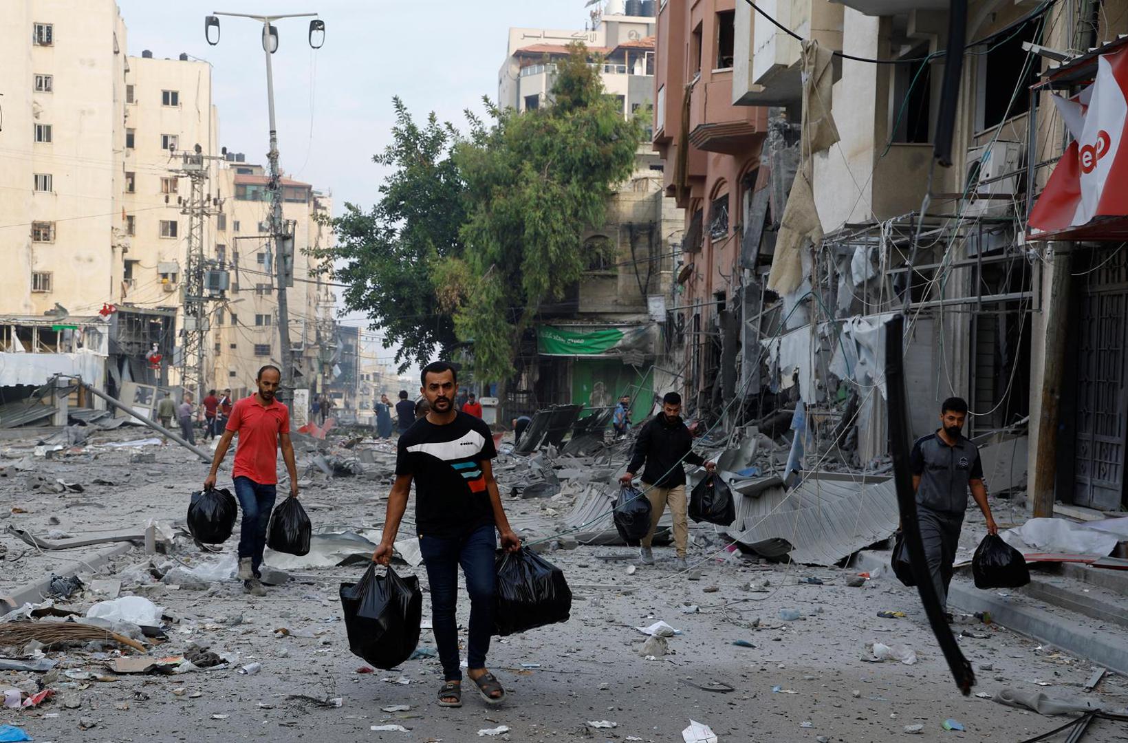 Palestinians walk amid debris in the aftermath of Israeli strikes, in Gaza City, October 11, 2023. REUTERS/Mohammed Salem Photo: MOHAMMED SALEM/REUTERS