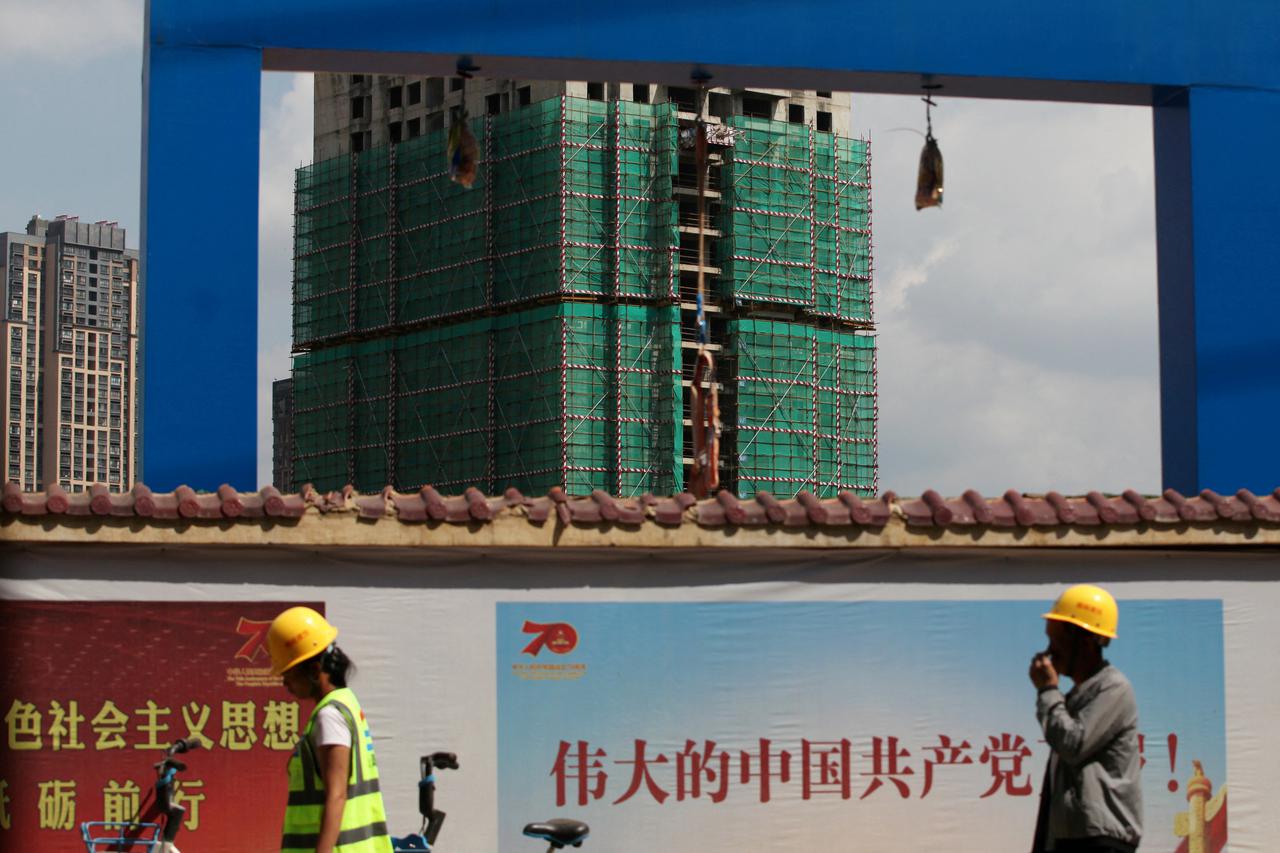 FILE PHOTO: Workers walk past a construction site of residential buildings by property developer Country Garden in Kunming, Yunnan