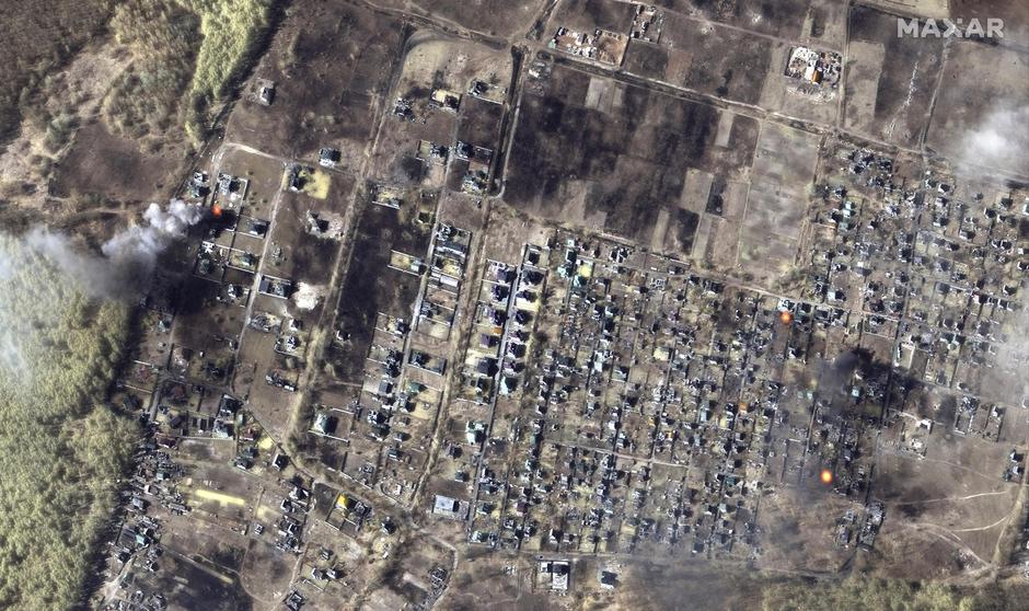 A satellite image shows a color infrared view of burning homes in Moschun