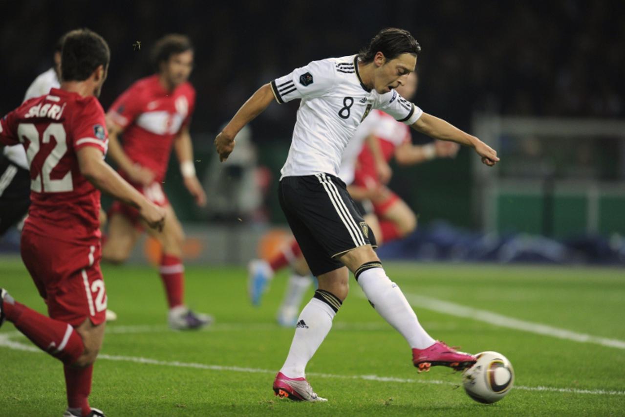 'Germany\'s midfielder Mesut Oezil (R) shoots watched by Turkey\'s defender Sabri Sarioglu during the Euro 2012 qualifying soccer match between Germany and Turkey at the Olympia stadium in Berlin, Oct