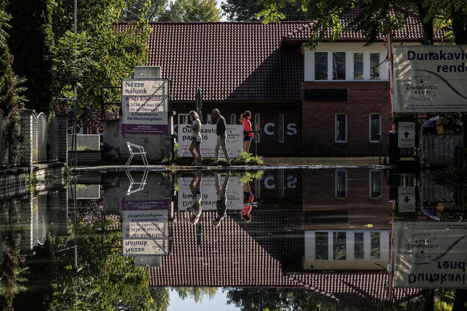 People walk by the houses flooded by the Danube River in Budapest, Hungary, September 21, 2024. REUTERS/Marko Djurica Photo: MARKO DJURICA/REUTERS