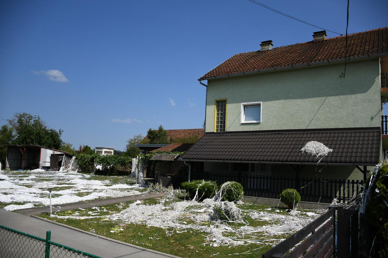 22.07.2023., Garesnica - Pogled na prvu zavara i izgleda kao da je na + 35 stupnjeva dvoriste obiteljske kuce zatrpano snijegom. Medjutim na podrucju Bjelovarsko-bilogorske zupanije njeguje se nesvakidasnji obicaj "slavlja" dolaska kuci majke i novorodjenceta iz bolnice, poznat pod nazivom sipanje. Rodbina, prijatelji i susjedi iskazuju veselje zasipavanjem dvorista perjem i papirima, a neuobicajeni nestasluci postaju ocekivani dio slavlja. Ovo je obicaj koji nema pisana pravila pa on ovisi o "kreativnosti" sipaca. Nakon slavlja, domacini ove obiteljske kuce u Garesnici imati ce pune ruke posla da sve ociste i vrate u prvobitno stanje.  Photo: Damir Spehar/PIXSELL