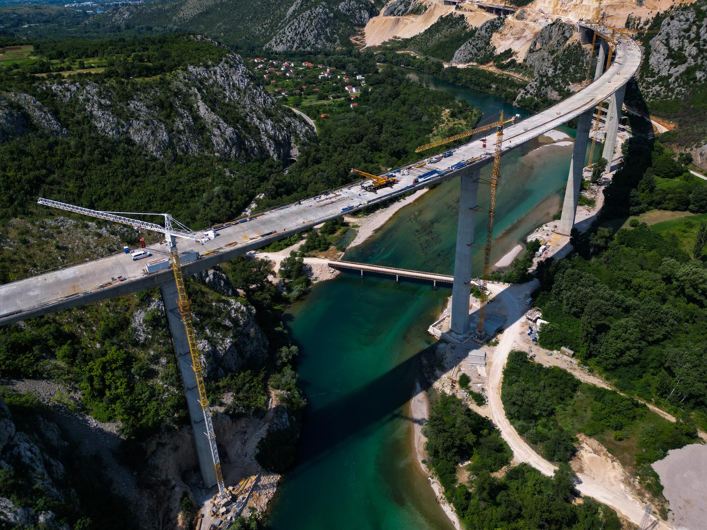 18.06.2023.,Capljina -  Jedan od najvisih mostova u regiji, most Pocitelj uskoro ce biti  spojen s lijevom obalom Neretve. Most Pocitelj visok je nesto vise od stotinu metara, dok njegova duzina iznosi 918 metara. Most ce imati dva vozna traka u svakom smjeru, te je projektiran za brzinu do 130 kilometara na sat. Specificnost ovog mosta je da se citava sirina raspona nalazi na jednostrukom nizu stupova, tj, kolnici nisu fizicki odvojeni. Most Pocitelj najveci je objekt na koridoru Vc. 


 Photo: Denis Kapetanovic/PIXSELL