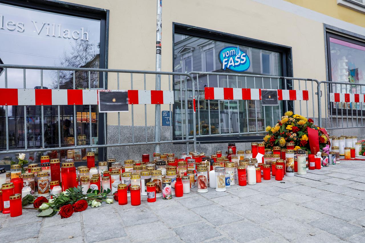 Candles and flowers sit at the scene where a 14-year-old boy was killed and several others were wounded in a stabbing attack, in the town of Villach