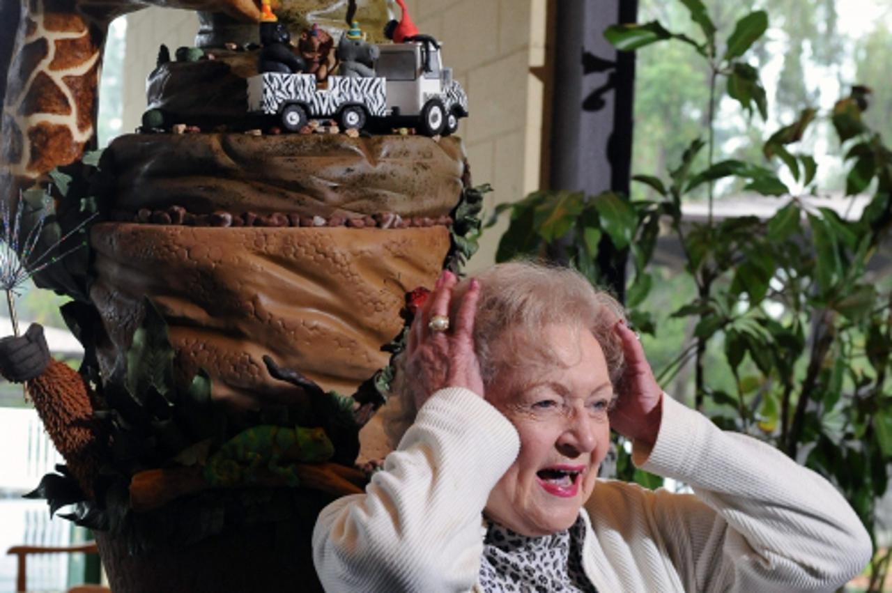 'WORLD RIGHTS NO USA, FRANCE, AUSTRALIA.  Actress Betty White stands beside a life-sized chocolate blackout cake in honor of her 90th birthday decorated with White\'s favorite animals , including a gi