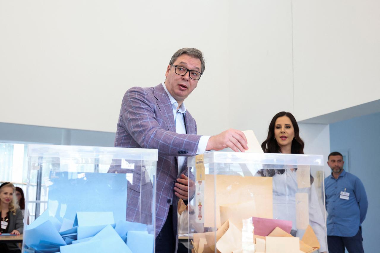 Serbian President Aleksandar Vucic casts his ballot accopanied by his wife Tamara Vucic at a polling station