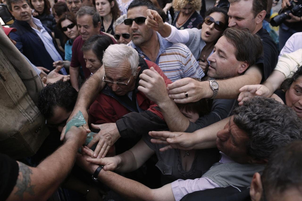 'People reach out to take fruits and vegetables distributed for free by street market vendors, who sell produce from their farms, in a symbolic protest against government plans to change the status of