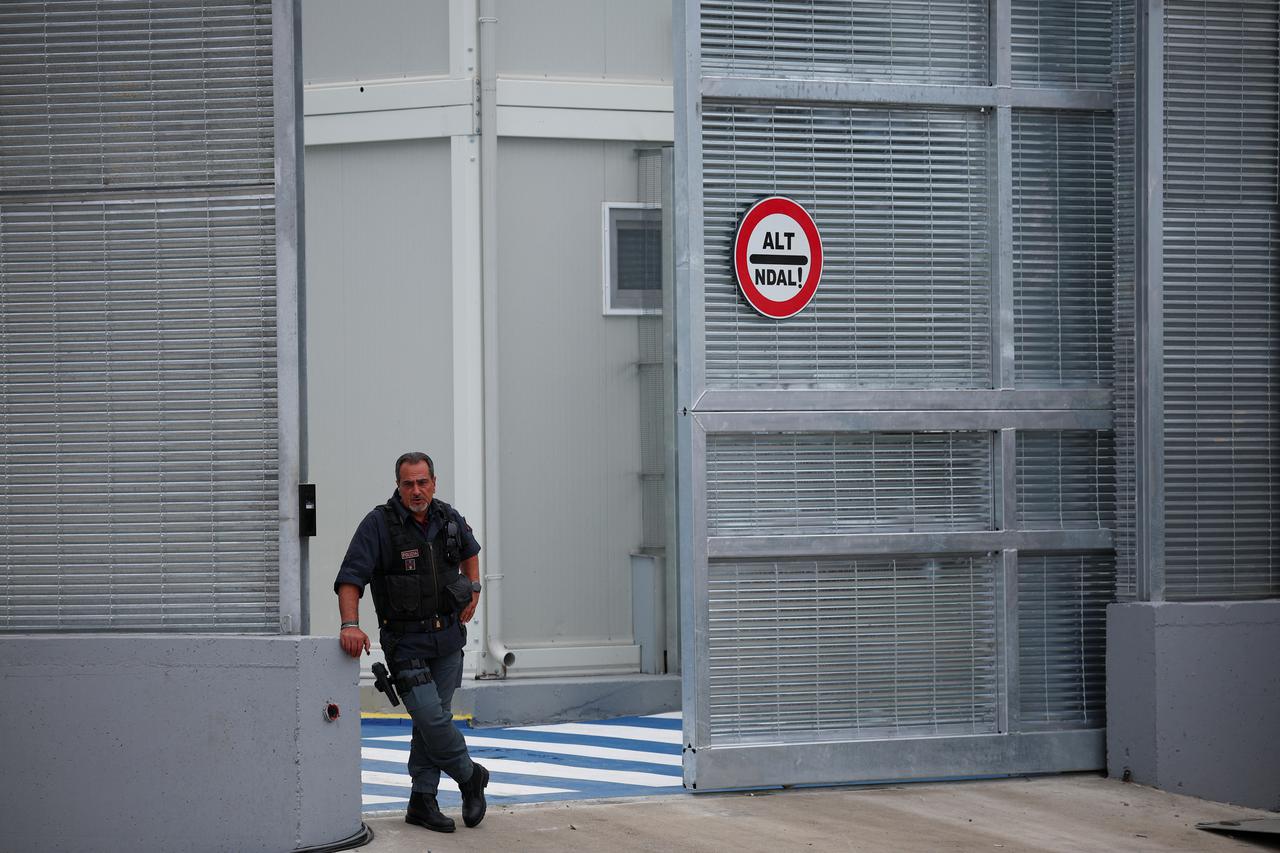 A member of the Italian police stands at the reception camp at the port, in Shengjin