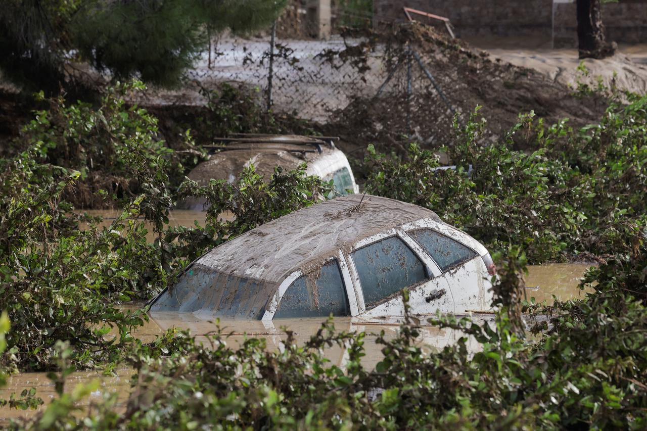 Cars sit submerged in a flooded area after heavy rains and floods in Alora